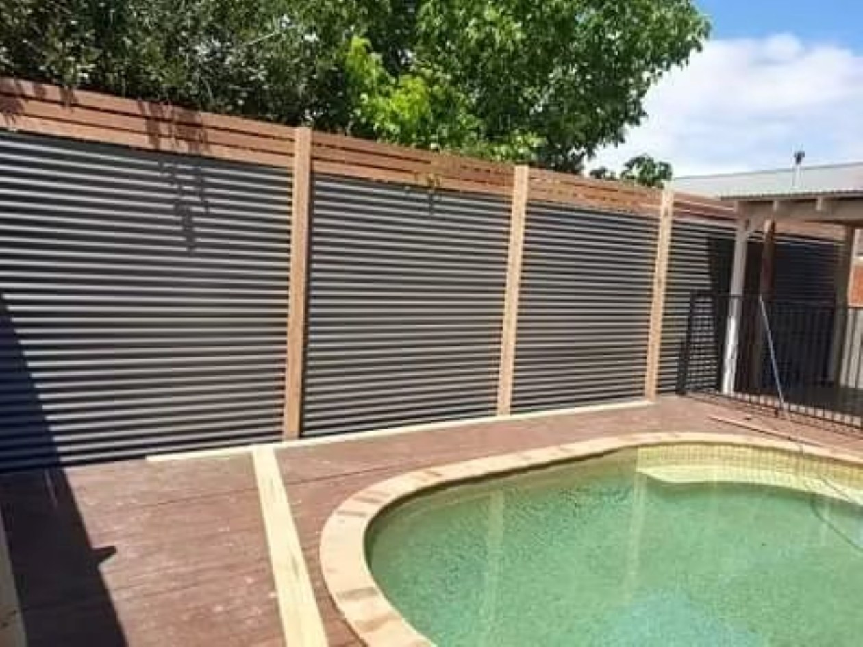 Colorbond and timber boundary fence beside a pool